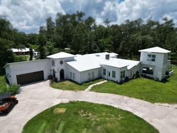 Stunning exterior view of this unique home with a pristine white roof and charming architectural details at 21921 Us Highway 98, Dade City, FL 33523