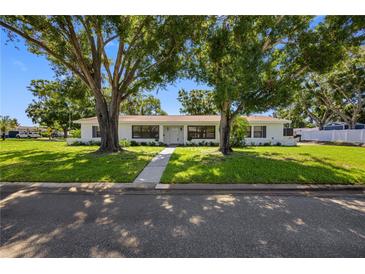 Beautiful home with a manicured lawn and mature trees lining the walkway and the property at 4391 Ne Cherry Ne St, St Petersburg, FL 33703