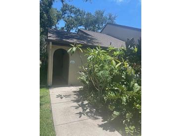Charming entryway with lush greenery and a decorative arch at 6262 142 N Ave # 1001, Clearwater, FL 33760