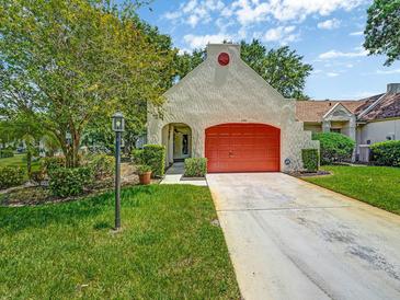 Charming single-story home with a bright red garage door and well-maintained lawn and landscaping at 8336 Monaco Dr # A, Port Richey, FL 34668