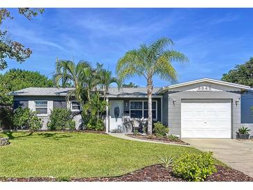 Charming single story home with a manicured lawn, tropical landscaping, and an attached garage in a desirable neighborhood at 8848 56Th N Way, Pinellas Park, FL 33782