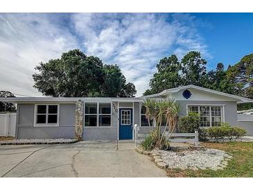 Charming single-story home with a well-maintained lawn, blue front door, and updated windows at 310 4Th Ave. Southwest, Ruskin, FL 33570