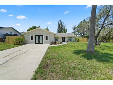 Inviting single-story home with fresh exterior paint, a well-manicured lawn, and a concrete driveway at 561 Golf And Sea Blvd, Apollo Beach, FL 33572