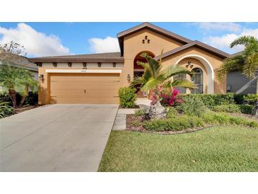 Charming single-story home featuring a two-car garage and well-maintained landscaping at 7408 Sungold Meadow Ct, Apollo Beach, FL 33572
