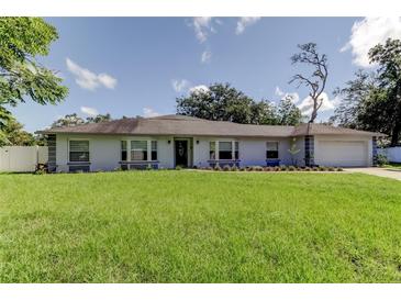 Charming single-story home featuring a manicured lawn and inviting curb appeal on a sunny day at 1402 Provincetown Cir, Lutz, FL 33549