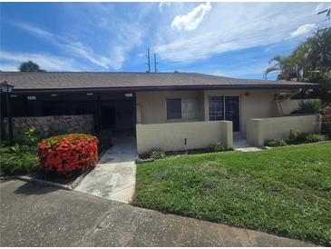 Charming single-story home with a well-maintained lawn and vibrant red bushes under a sunny sky at 1508 16Th Se Cir, Largo, FL 33771