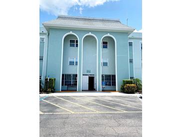 Inviting exterior of building with striking arches, well-maintained landscaping and accessible parking at 1706 Belleair Forest Dr # 146, Belleair, FL 33756