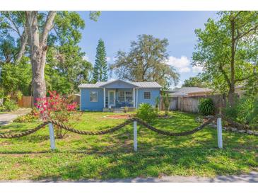 Charming blue bungalow with a beautifully landscaped yard and unique rope fence at 1912 E 97Th Ave, Tampa, FL 33612