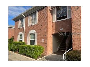 Brick condo building featuring shuttered windows, greenery, and covered stair access at 3535 41St S Ter # 219, St Petersburg, FL 33701