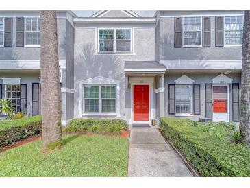 Townhouse exterior with red front door, updated landscaping, and neutral stucco facade at 367 Countryside Key Blvd, Oldsmar, FL 34677