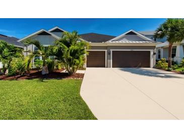 Beautiful home with a two-car garage, well-manicured lawn and tropical landscaping at 4906 Los Robles Ct, Palmetto, FL 34221