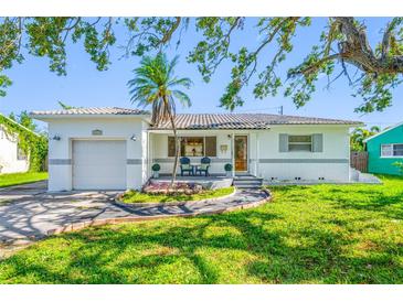 Charming single-story home featuring a well-maintained lawn, inviting front porch, and attached garage at 6219 Hampton N Dr, St Petersburg, FL 33710
