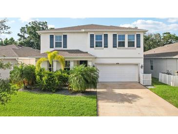 Charming two-story home featuring a well-maintained lawn, tropical landscaping, and a two-car garage at 8305 Praise Dr, Tampa, FL 33625