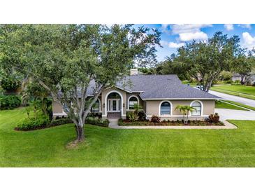 Charming one-story home with a beautifully landscaped front yard and arched entryway at 8901 Eagle Watch Dr, Riverview, FL 33578
