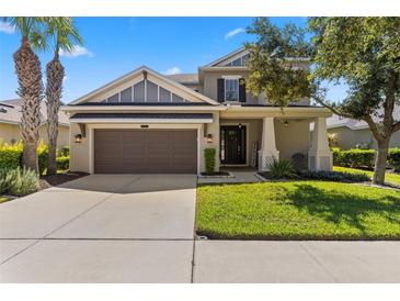 Charming home with a well-manicured lawn, a welcoming entrance, and a two-car garage at 9275 Bella Vita Cir, Land O Lakes, FL 34637