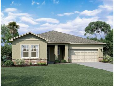 Charming single-story home featuring a two-car garage, stone accents, and a well-manicured lawn at 14710 Italy Ave, Dade City, FL 33523