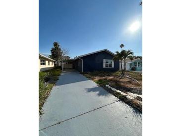 Charming single-story home with a well-maintained lawn and a long driveway at 15416 2Nd E St, Madeira Beach, FL 33708