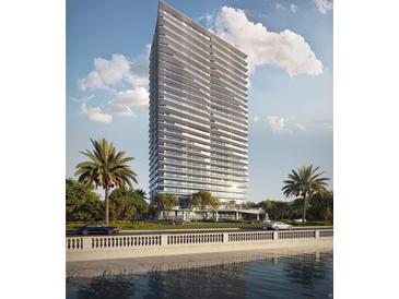 Modern high-rise condo building with sleek design, multiple balconies, lush landscaping, and serene waterfront views at 2912 W Santiago St # 803, Tampa, FL 33629