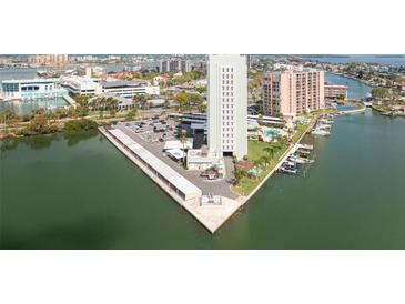 Expansive aerial view of the building showing a marina, covered parking, and surrounding neighborhood at 31 Island Way # 502, Clearwater Beach, FL 33767