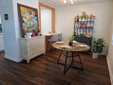 Bright dining room featuring dark wood flooring and a charming round dining table at 5925 Terrace Park N Dr # 210, St Petersburg, FL 33709
