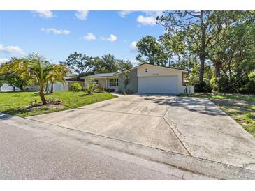 Charming single-story home featuring a two-car garage, mature trees, and a well-manicured lawn at 5998 8Th S St, St Petersburg, FL 33705