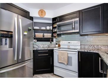Updated kitchen features stainless steel refrigerator, granite counters and abundant cabinet space at 6932 Stones Throw N Cir # 7101, St Petersburg, FL 33710