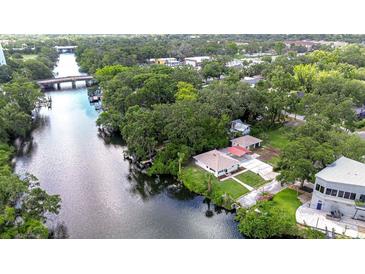 Stunning aerial view of the home nestled on the river, surrounded by lush greenery and beautiful landscaping at 8001 N Highland Ave, Tampa, FL 33604
