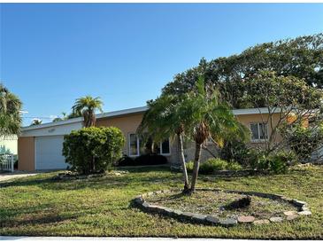 Charming single-story home with well-maintained lawn and mature trees, and a one car garage at 103 9Th St, Belleair Beach, FL 33786