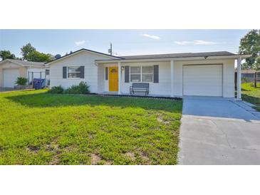 Charming single story home features a bright yellow front door and attached garage at 1426 Gerard Ln, Holiday, FL 34690