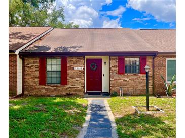 Charming brick townhouse featuring red shutters and a matching front door with a festive wreath at 35140 Whispering Oaks Blvd, Dade City, FL 33523