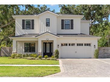 Beautiful two-story white home featuring black shutters, well-manicured lawn, and spacious two car garage at 4114 W Neptune St, Tampa, FL 33629