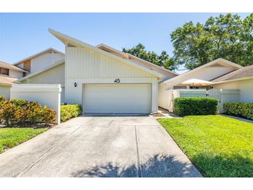Inviting exterior showcasing a well-maintained facade, garage, and landscaped front yard of home number 45 at 498 Lakeview Dr # 45, Palm Harbor, FL 34683