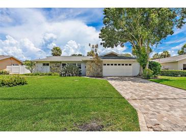 Charming single-story home with stone accents, lush lawn, and a brick driveway at 5285 Dover Ne St, St Petersburg, FL 33703