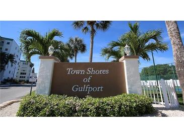 Welcoming entrance sign for Town Shores of Gulfport surrounded by lush landscaping and palm trees at 6025 Shore S Blvd # 408, Gulfport, FL 33707