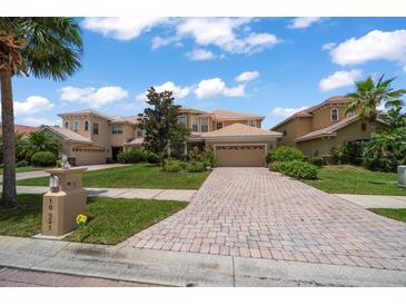 Charming two-story home featuring a tile roof, brick driveway, and well-manicured landscaping at 10921 Cory Lake Dr, Tampa, FL 33647