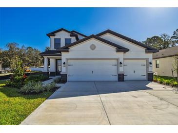 Beautiful two-story home featuring a three car garage and manicured front lawn at 11311 Striped Bass Ct, New Port Richey, FL 34654