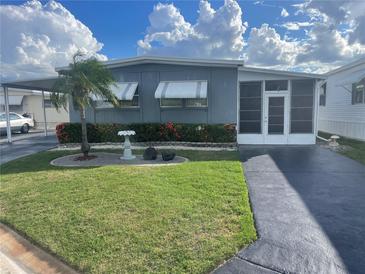 Charming single-story home with a well-manicured lawn, beautiful landscaping, and a covered parking area at 124 Saint Pierres Way, Apollo Beach, FL 33572
