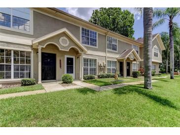 Inviting townhouse exterior features a well-maintained lawn and neutral color scheme at 2898 Thaxton Dr # 76, Palm Harbor, FL 34684