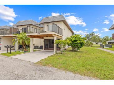 Two-story townhome with a balcony, carport, and well-maintained lawn and landscape at 3368 Ramblewood Pl # 37-D-1, Sarasota, FL 34237