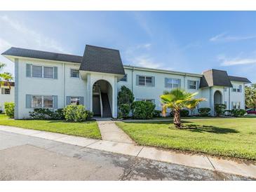 Two-story condo complex with lush landscaping and a well-manicured lawn at 387 S Mcmullen Booth Rd # 16, Clearwater, FL 33759