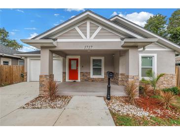 Charming single-story home featuring a bright red door, stone accents, and well-manicured landscaping at 1717 Preston S St, St Petersburg, FL 33712