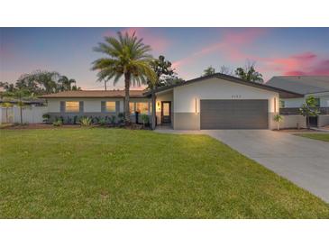 Charming single-story home featuring a manicured lawn and a spacious two-car garage at 3197 Walnut Ne St, St Petersburg, FL 33704