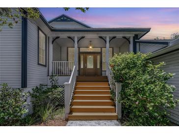 Charming home with a welcoming front porch and beautiful wood stairs at 389 Grand Bay Dr, Palm Harbor, FL 34683