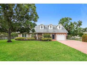 Charming one-story brick home featuring a large front yard with mature trees and manicured landscaping at 4611 W 18Th Ave, Bradenton, FL 34209