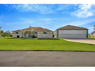 Charming single-story home with a well-manicured lawn and large airplane hangar at 11908 Pilot Country Dr, Spring Hill, FL 34610
