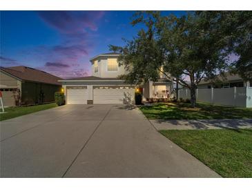 Two-story home with a three car garage, large driveway, and a well-maintained lawn at 13252 Graham Yarden Dr, Riverview, FL 33579