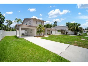 Two-story home with a long driveway, carport and well-maintained lawn at 1712 Azalea Ct # A, Oldsmar, FL 34677