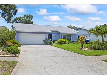 Charming single-story home with a well-manicured lawn, mature landscaping and a two car garage at 1983 Seton Dr, Clearwater, FL 33763