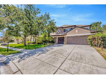 Beautiful two-story home with a three-car garage, well-maintained landscaping and a large driveway at 23320 Dinhurst Ct, Land O Lakes, FL 34639