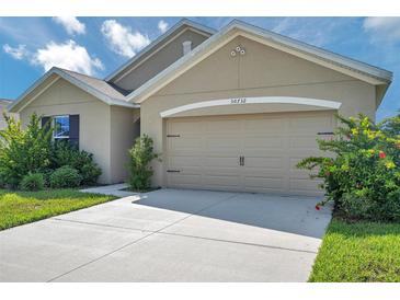 Charming home featuring an attached two-car garage and manicured landscaping at 30732 Summer Sun Loop, Wesley Chapel, FL 33545